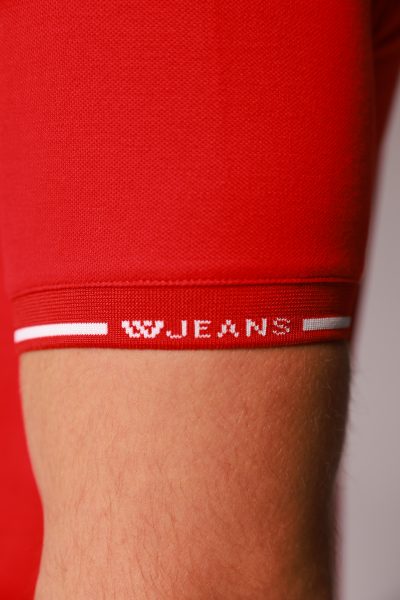 חולצת פולו בצבע אדום עם טקסט לוג W JENAS בצבע לבן על כפתורים קידמי ,פס לבן על הקצה של הצווארון , בגב החולצה לאורך טקסט W JEANS ארבע פעמים בצבע לבן, שרוולים קצרים עם פס לבן ולוגו WJ חולצה מבית W JEANS