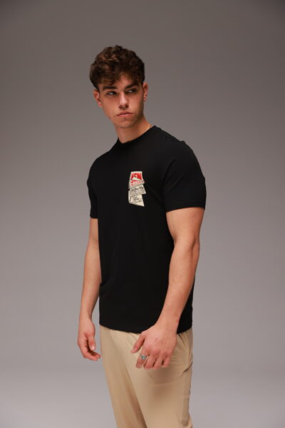 חולצת טישרט שחורה של W JEANS עם הדפס גרפי בכיס הקדמי, עשויה 95% כותנה 5% לייקרה.