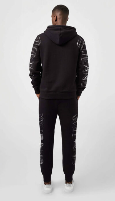 חליפת טרנינג שחורה לגבר של W JEANS – קפוצ'ון ומכנס עם הדפסי לוגו לבנים לאורך החזה, השרוולים והרגליים.