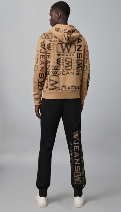 חליפת טרנינג מבית W JEANS הכוללת קפוצ'ון בצבע שקד, ומכנס שחור עם הדפסי לוגו בולטים בשחור, בעיצוב אורבני ייחודי.