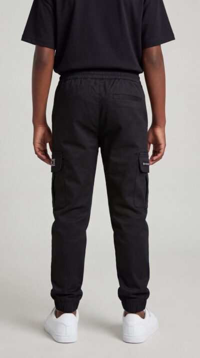 מכנס דגמ"ח שחור לילדים מבית W JEANS עם כיסי צד, גומי במותן ושרוך קשירה, בשילוב הדפסי לוגו.